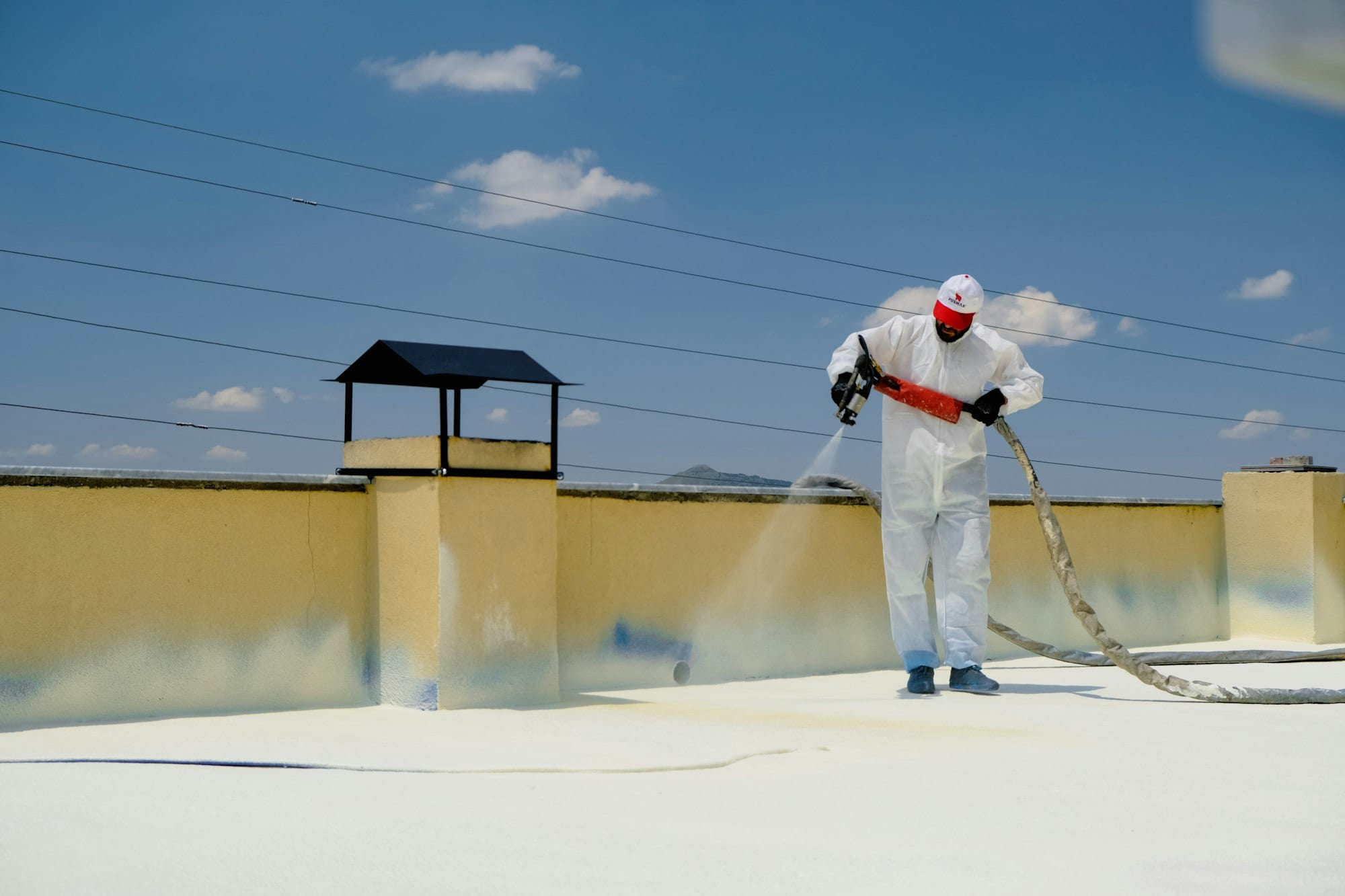 Étancheur appliquant une résine sur un toit-terrasse
