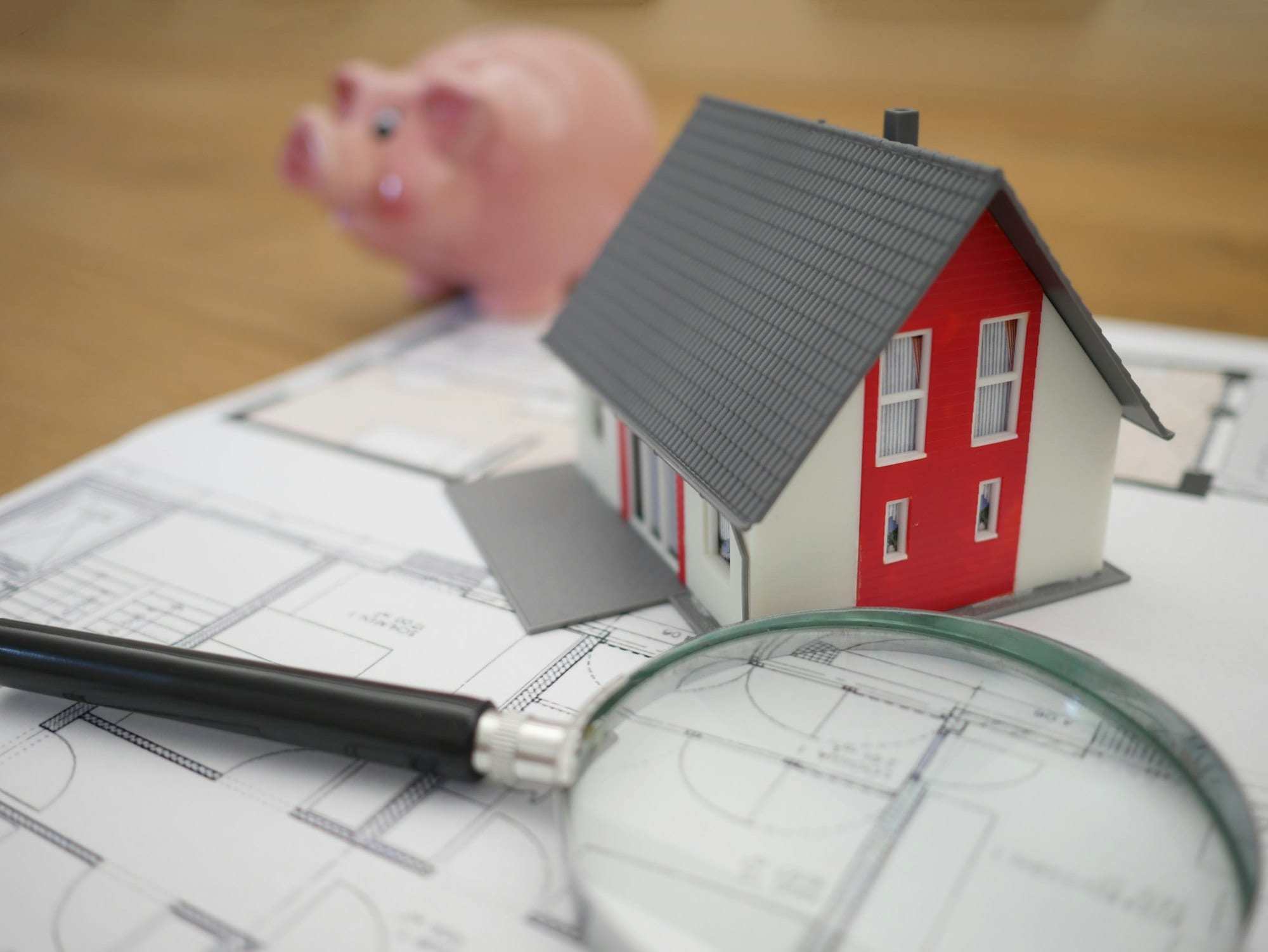 Maquette de maison et loupe posées sur un plan