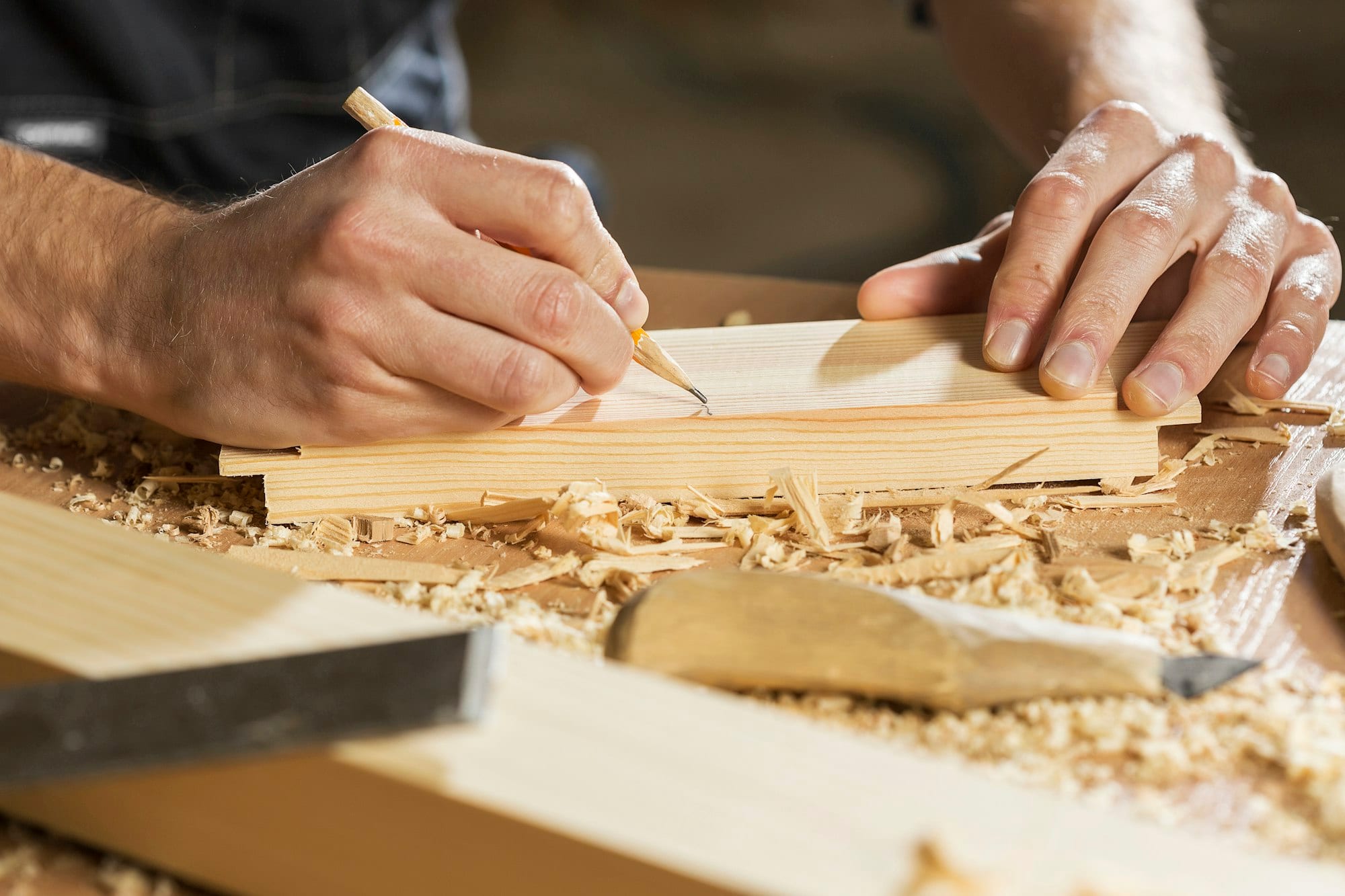 Menuisier traçant une coupe sur une planche de bois