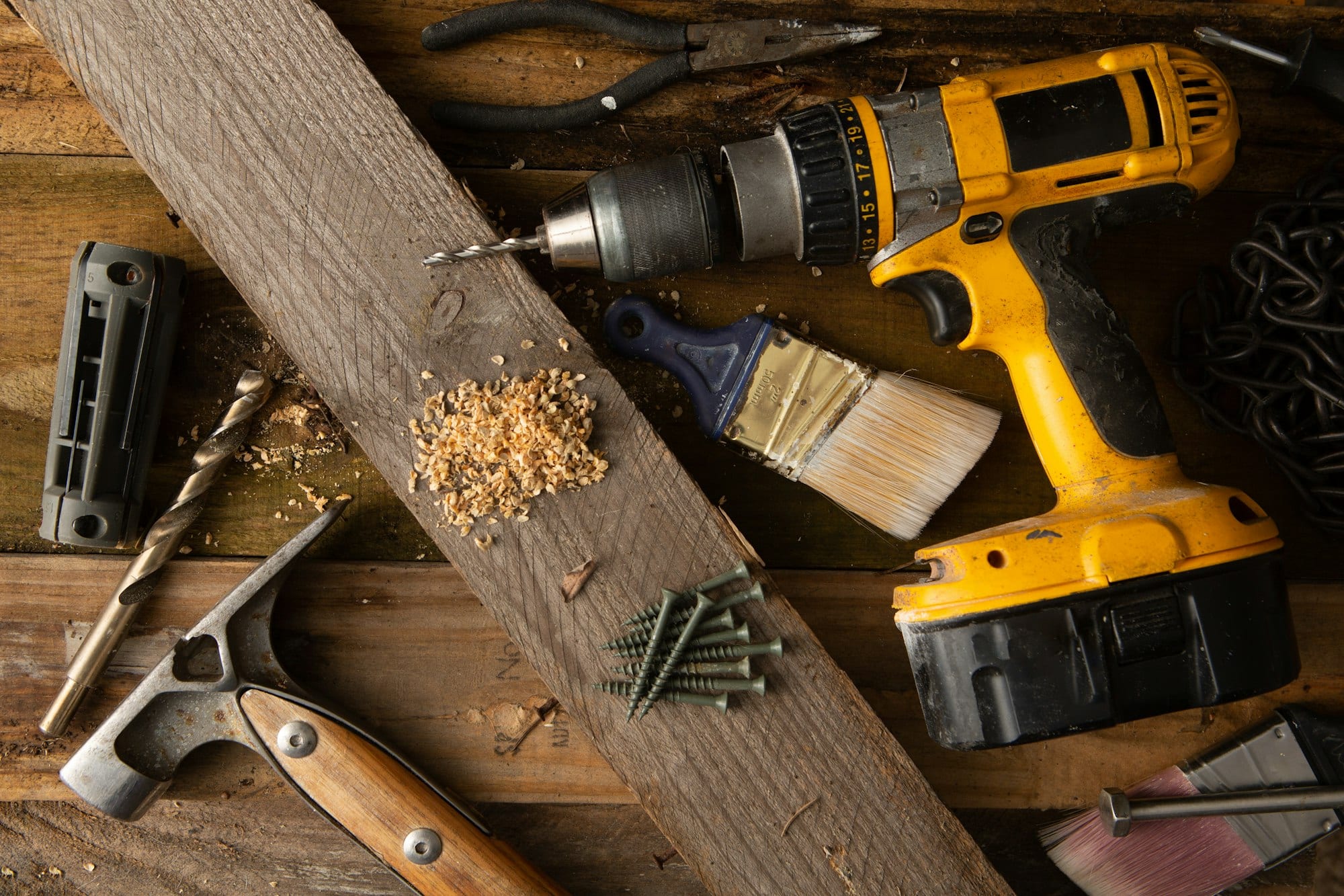 Perceuse et outils posés sur un établi en bois
