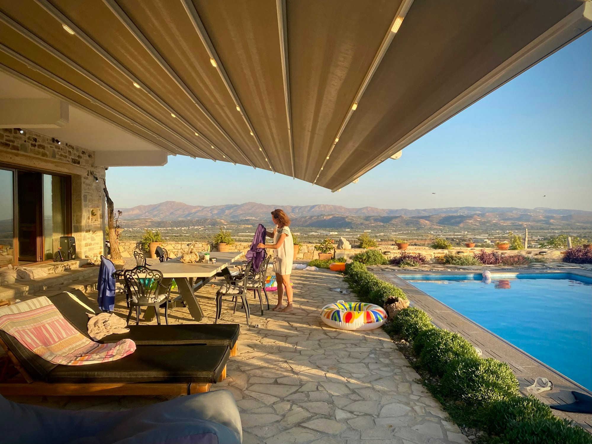 Store banne déployé au-dessus d'une terrasse avec piscine